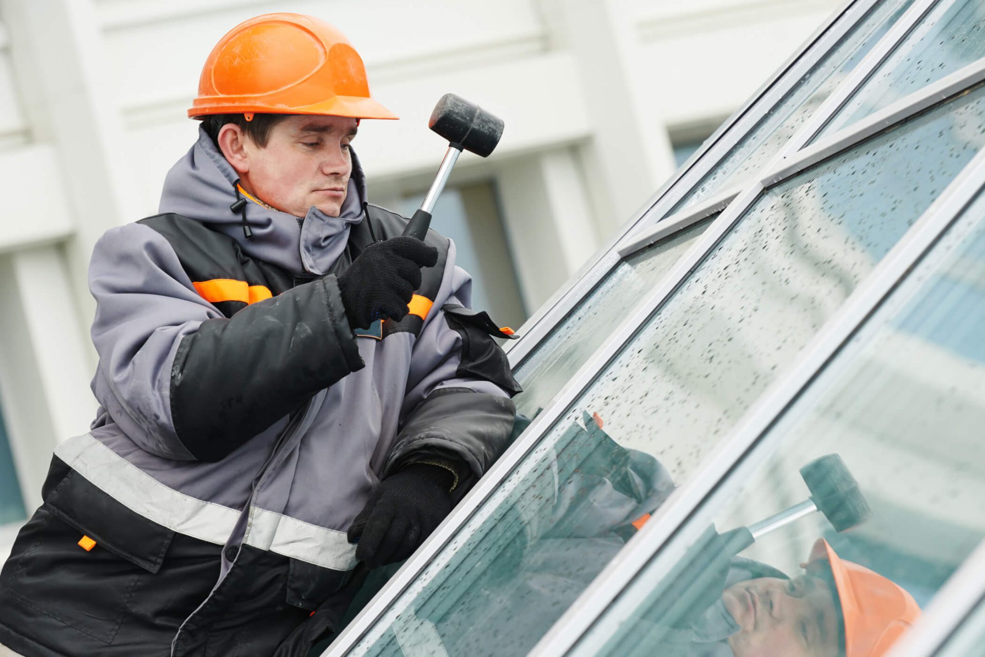 Glazing, glazier during work, cutting glass with glass cutter stock photo